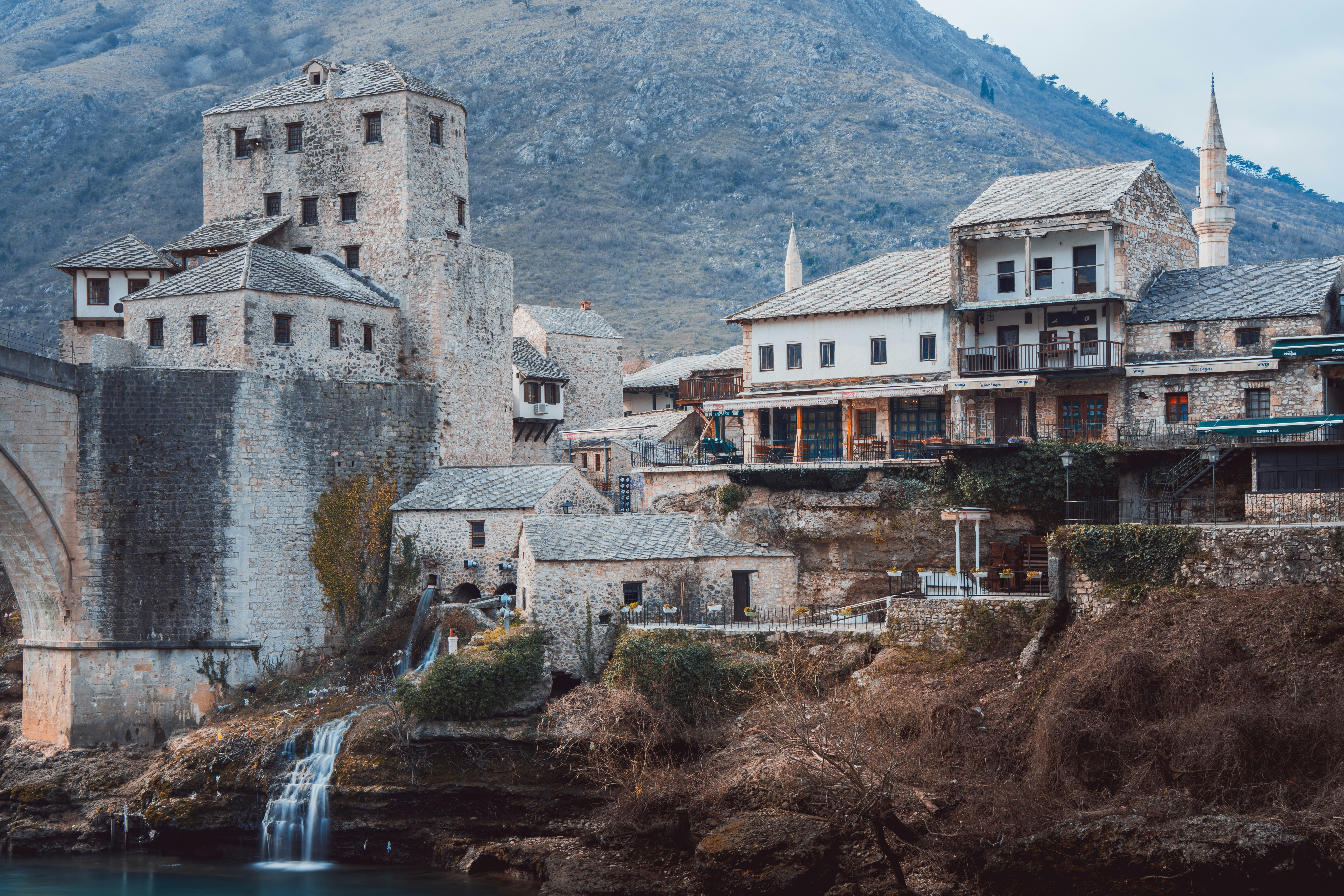 an old town with a waterfall in the middle of it