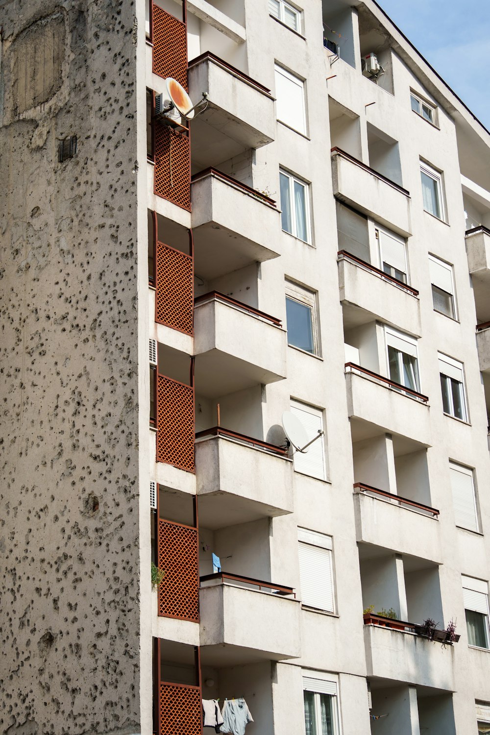 a tall white building with balconies and windows