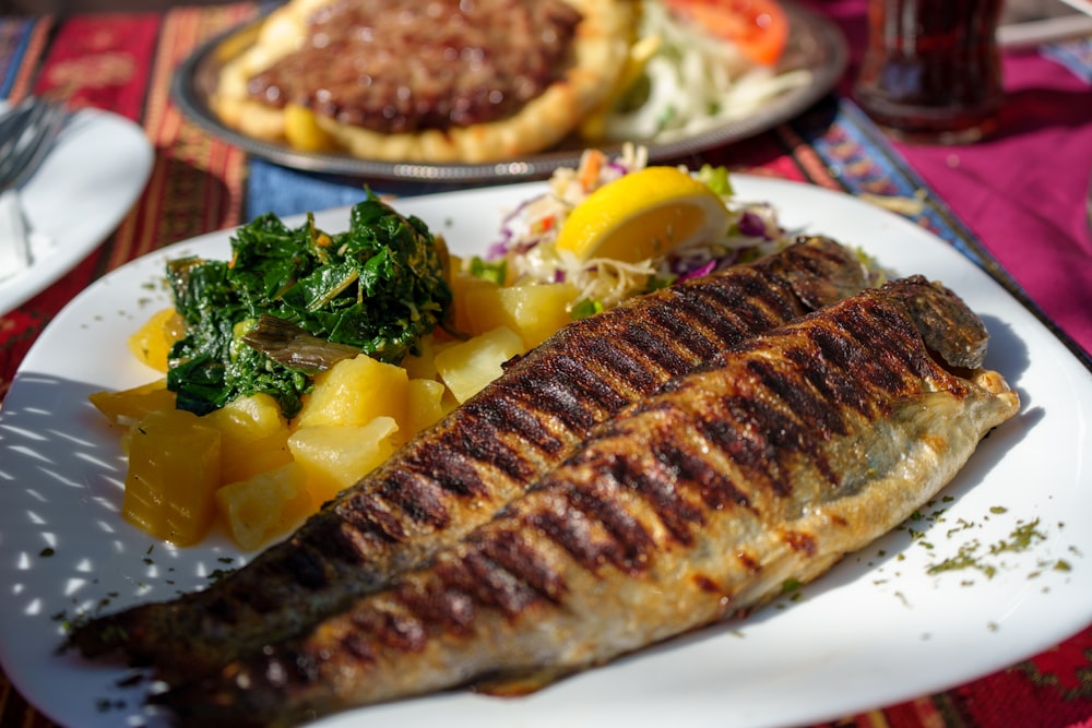 a plate of food with fish and vegetables on it