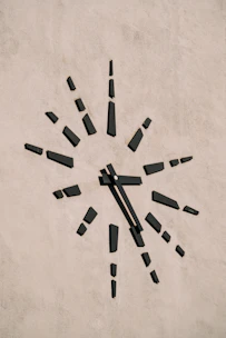A minimalist clock face dissolving into scattered digital numbers representing lost time.