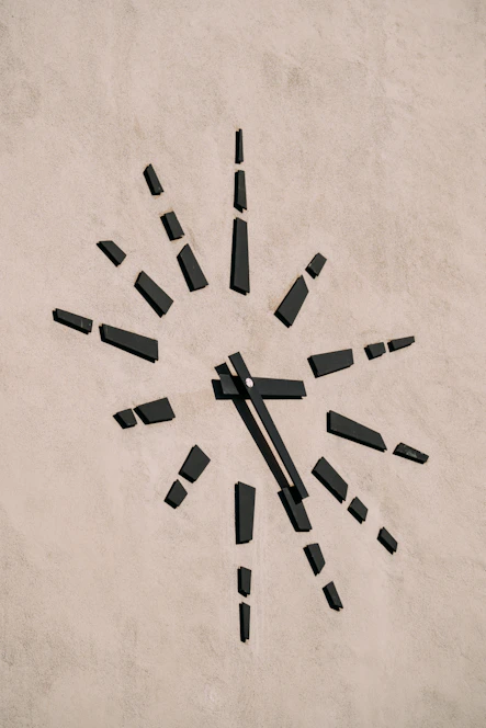 A minimalist clock face dissolving into scattered digital numbers representing lost time.