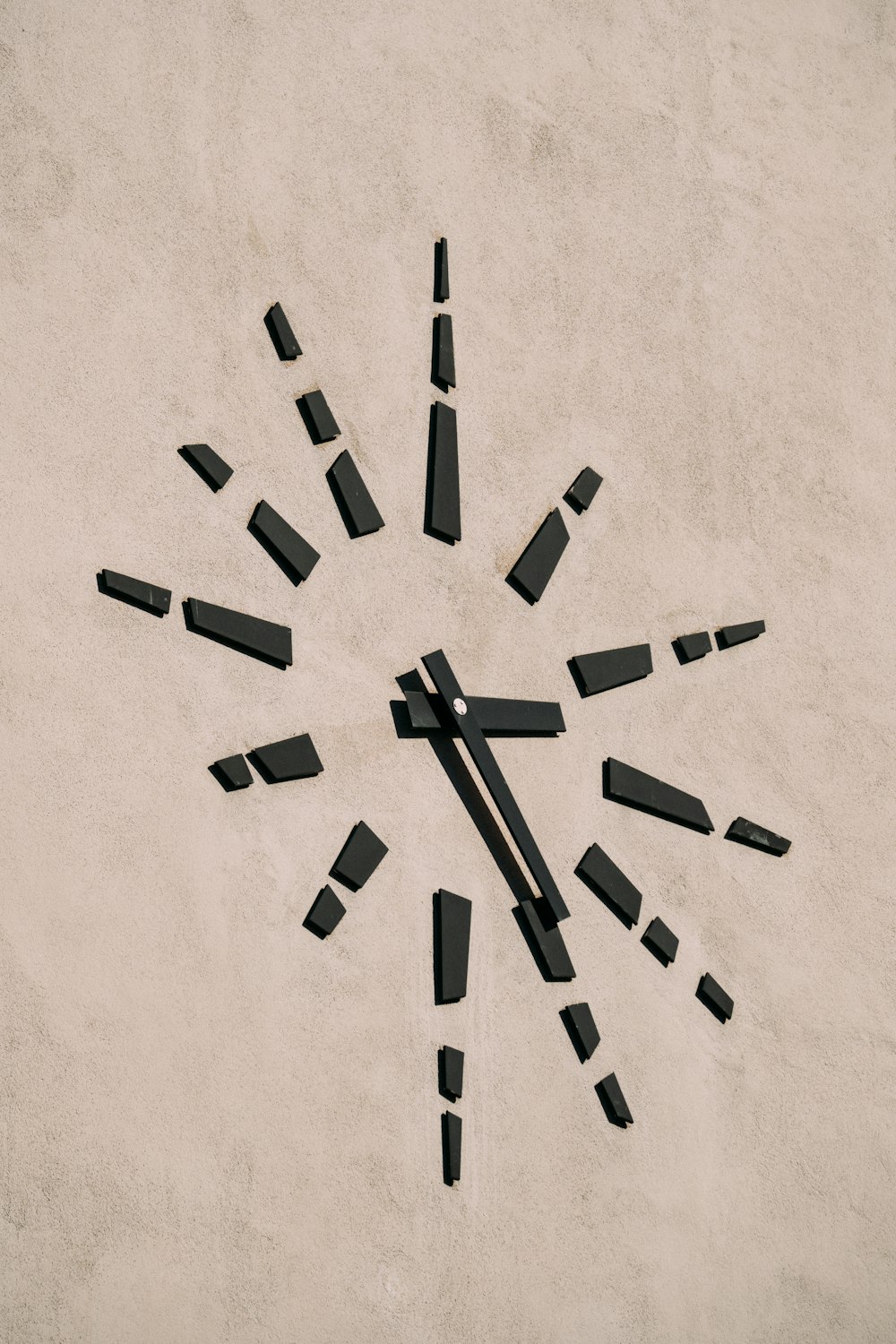 a clock made out of black pieces of wood