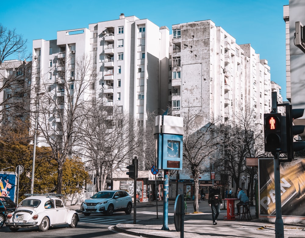 a city street with cars and people walking on the sidewalk