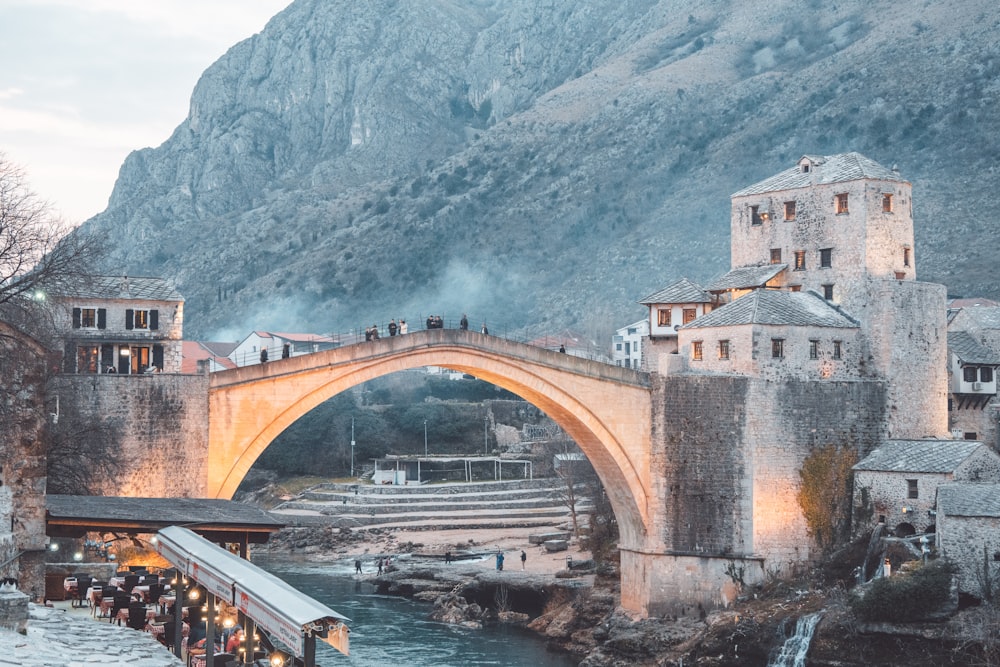 a bridge over a body of water near a mountain