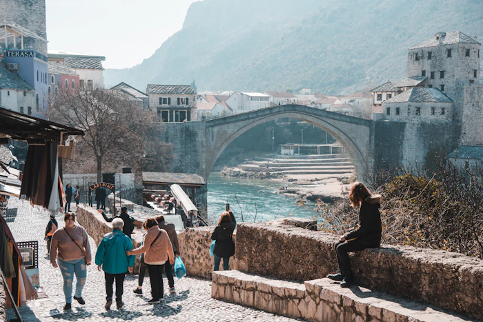 A group walking across a stone bridge