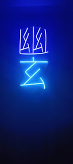 Neon lights in blue depict abstract geometric shapes against a dark background.