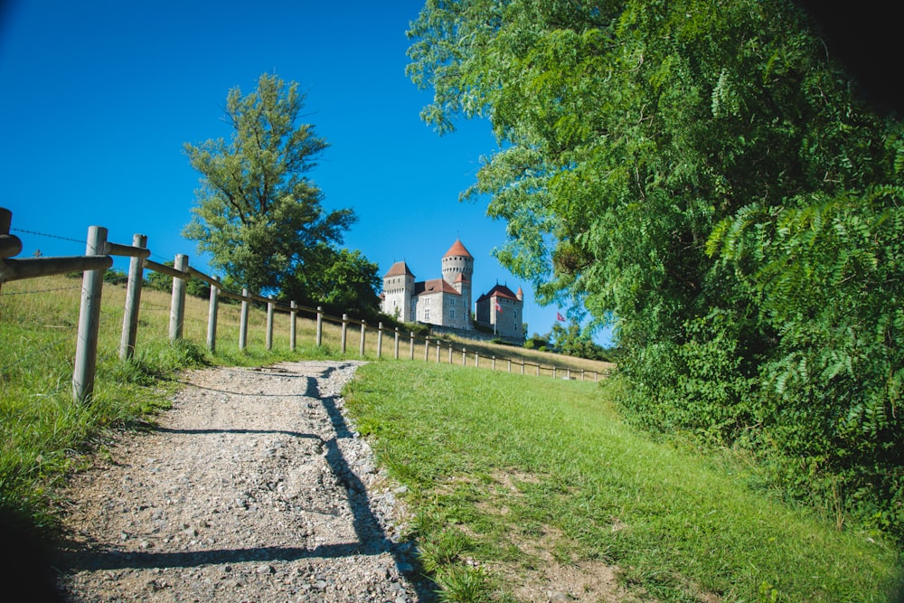 a large white building sitting on top of a lush green hillside