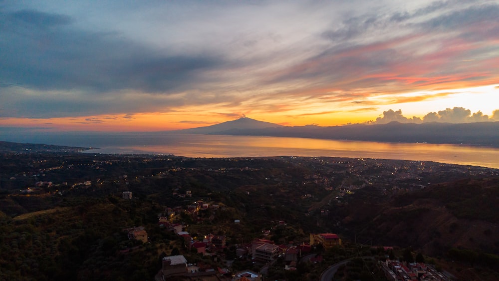 a view of a city and a lake at sunset