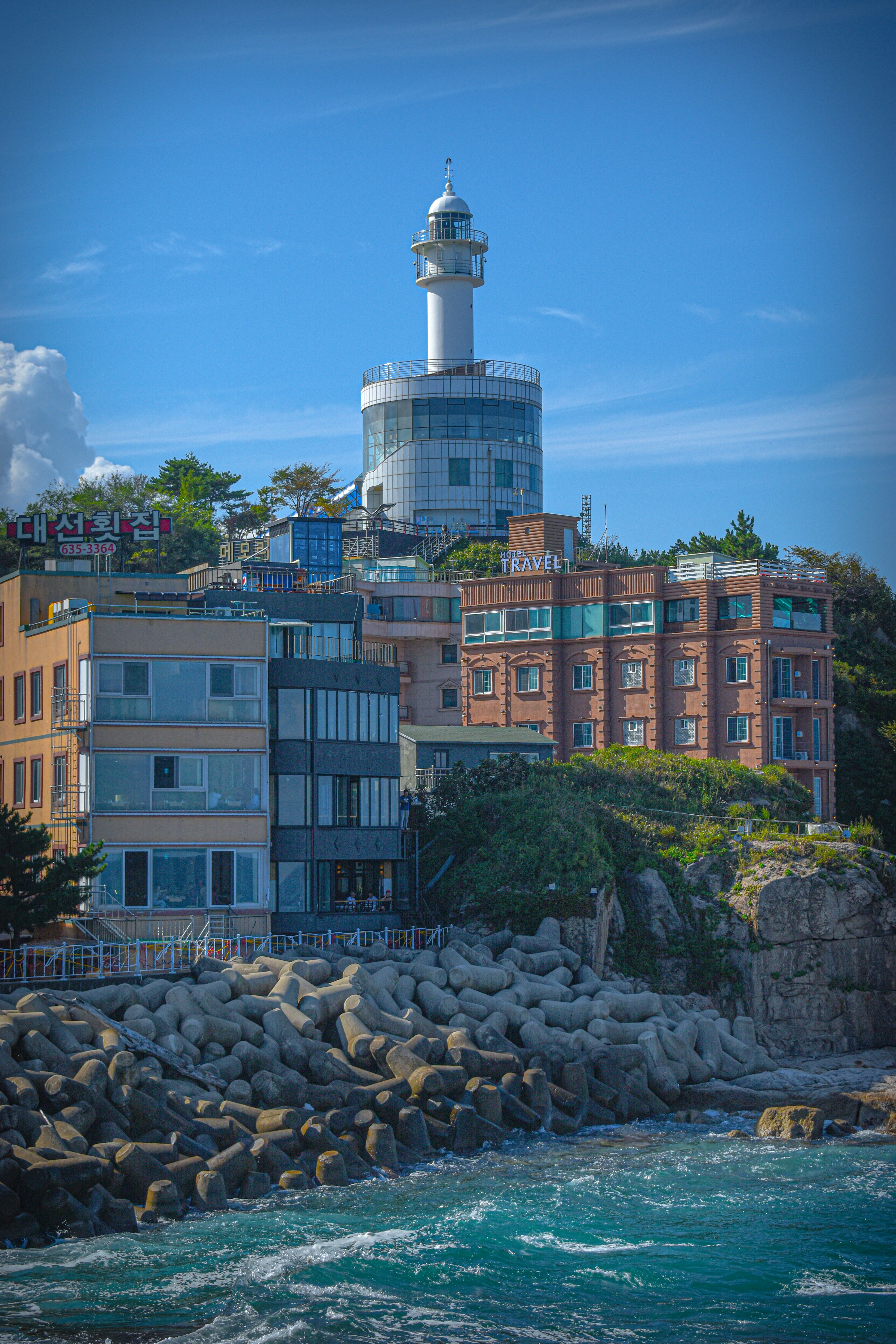 a lighthouse on top of a building next to a body of water