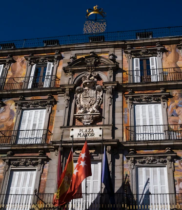 A vibrant photo of Madrid’s Plaza Mayor bathed in warm afternoon light.