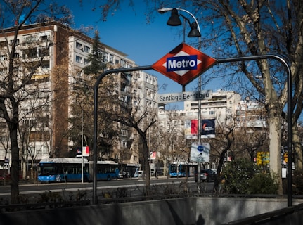 a metro sign hanging from the side of a metal pole