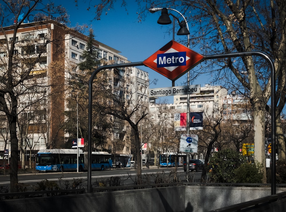 a metro sign hanging from the side of a metal pole