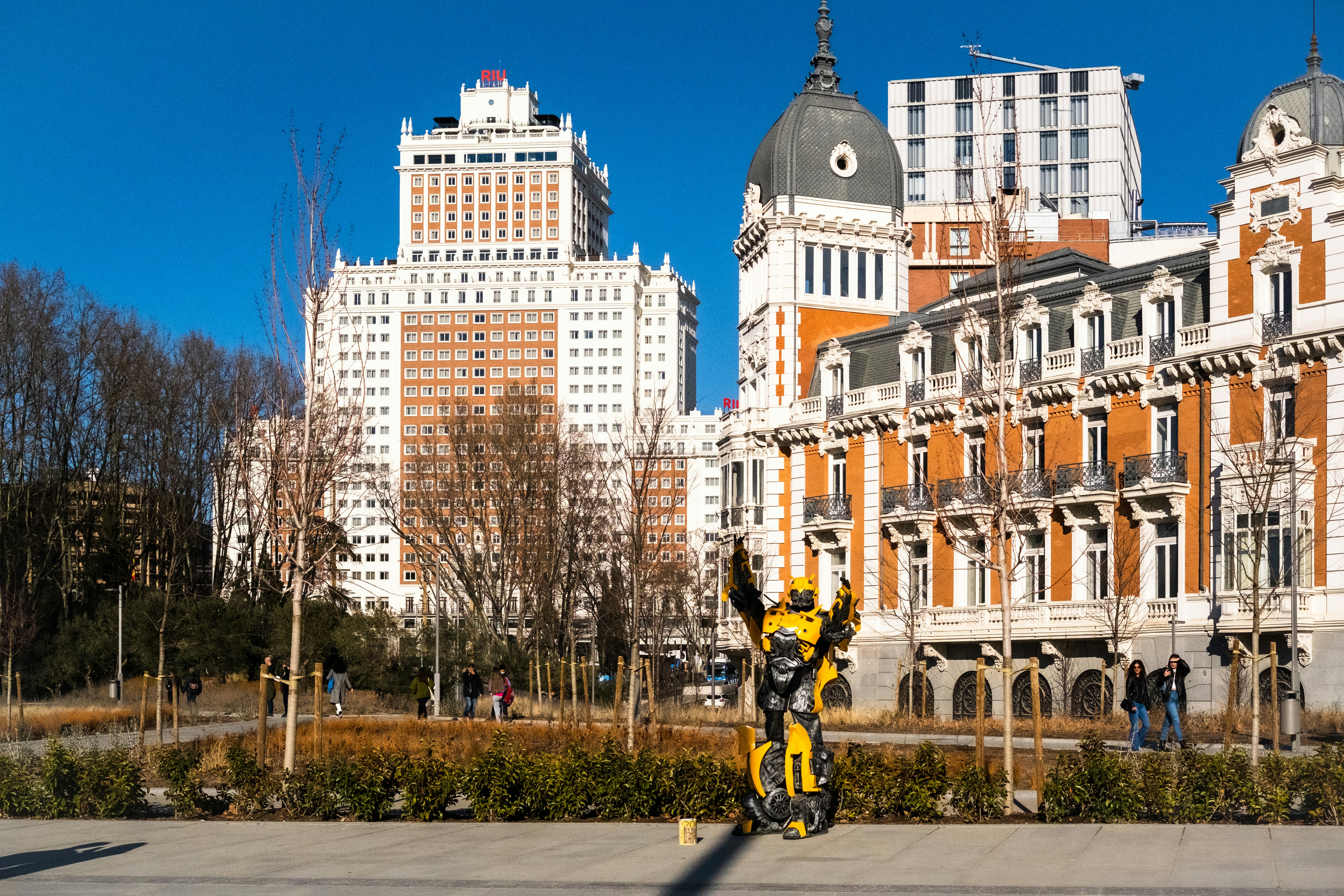 a statue of a robot standing in front of a building