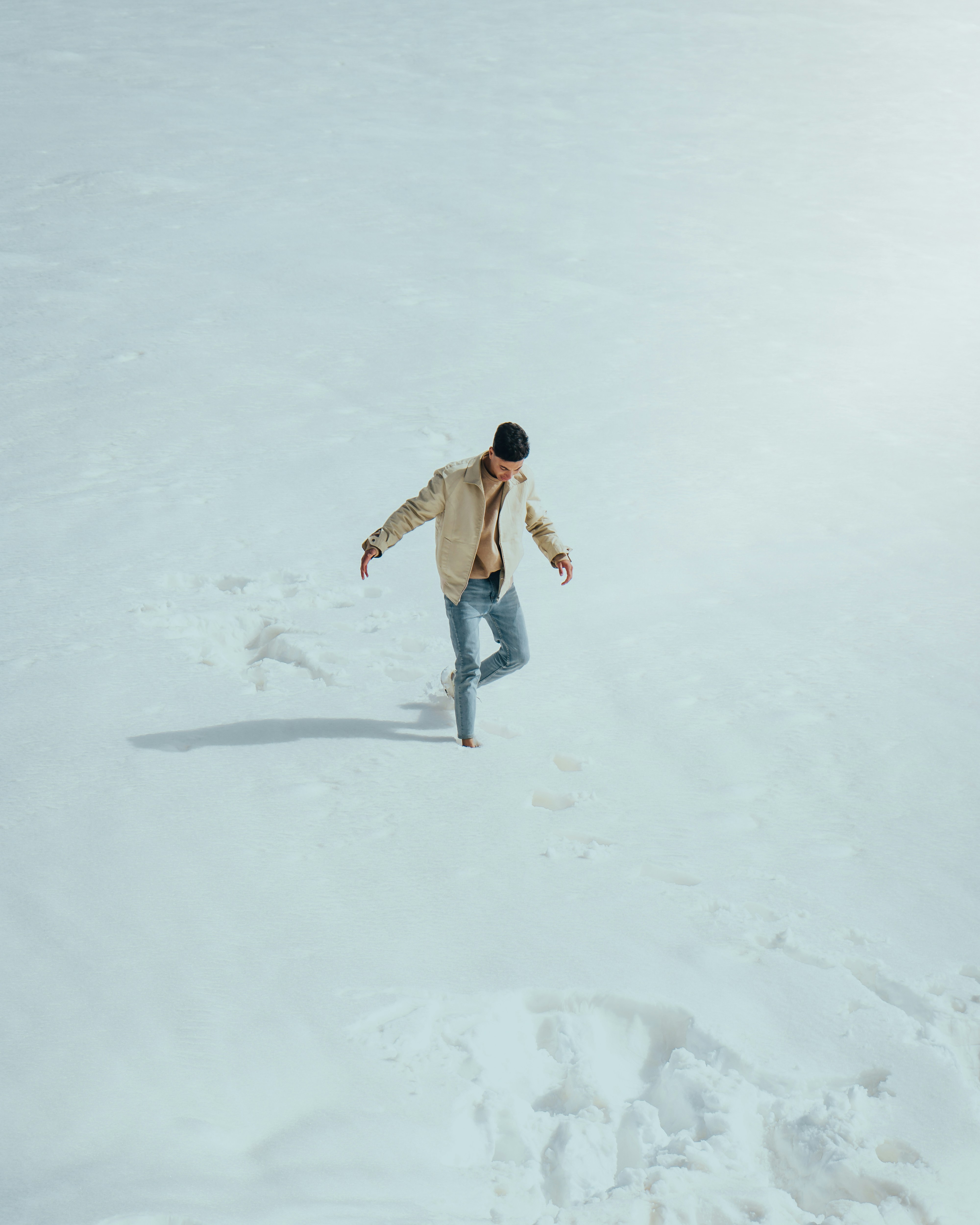 a man riding a snowboard down a snow covered slope
