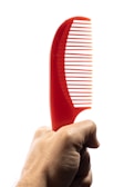 A person holding a sleek grooming tool, highlighting its ergonomic design.