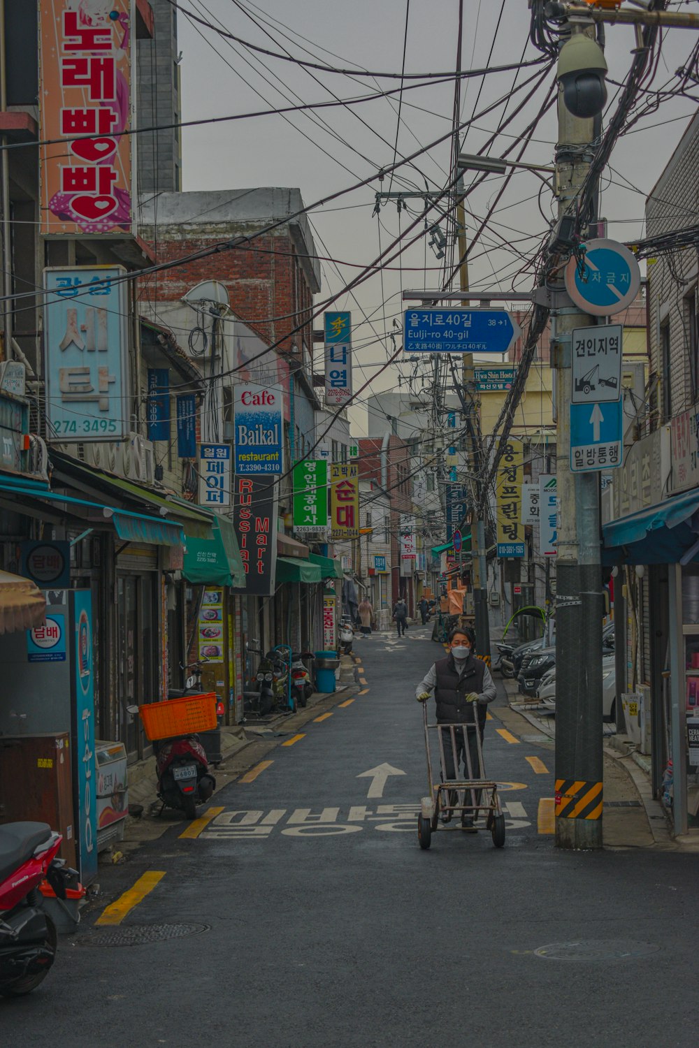 a person pushing a cart down a street