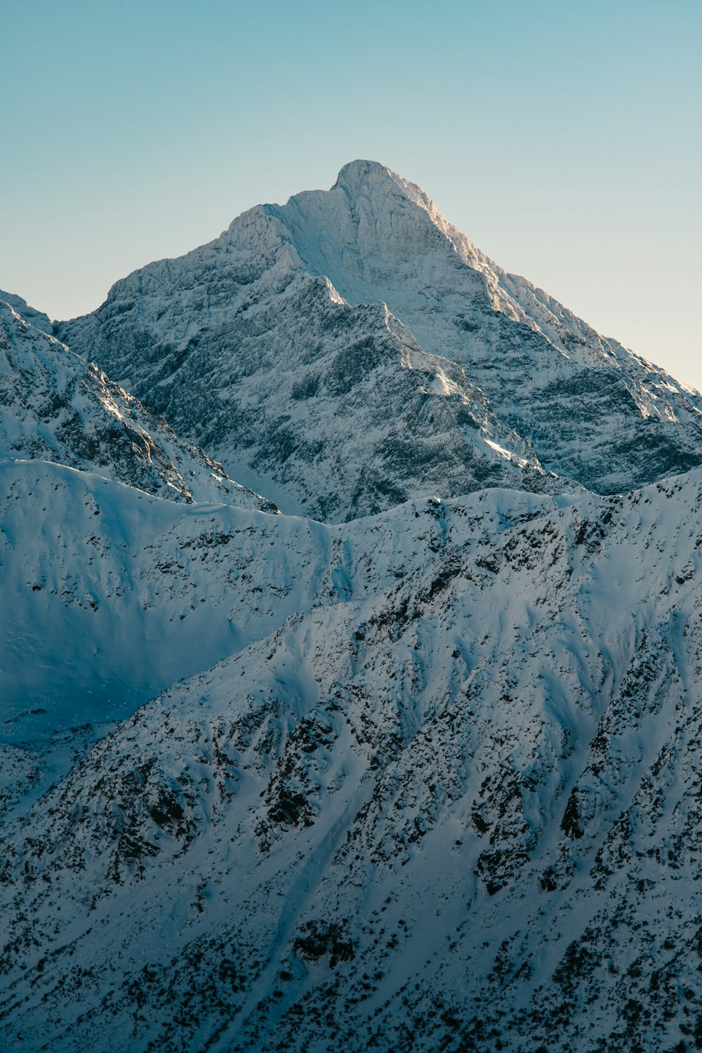 a mountain covered in snow with a sky background