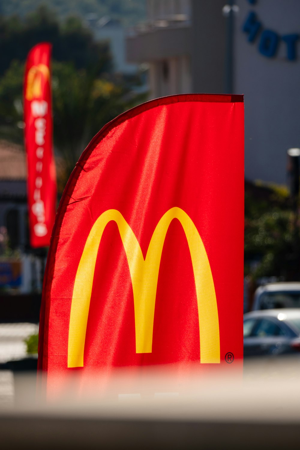 a mcdonald's sign with cars in the background