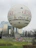 Large advertising inflatable shaped like a product logo at a busy outdoor fair.