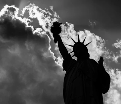 Statue of Liberty framed by a dramatic cloudy sky at dusk.