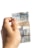 A hand holding a slightly worn two reais banknote with a turtle illustration, against a plain white background.