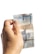A hand holding a slightly worn two reais banknote with a turtle illustration, against a plain white background.
