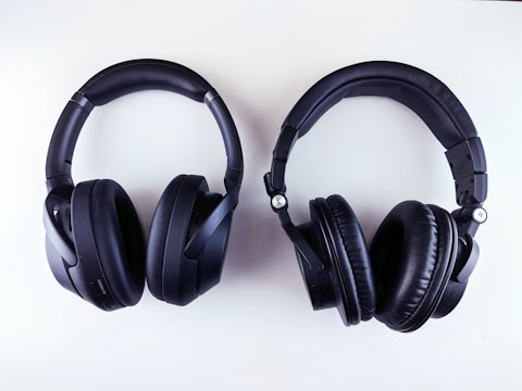 A pair of black over-ear headphones is placed against a white background. The headphones have thick, padded ear cups and an adjustable headband, with one labeled 'L' and the other 'R' for left and right sides.