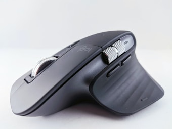 A sleek, ergonomic computer mouse designed for comfort and functionality, featuring a matte black finish with metallic scroll wheel and additional side buttons. The contours and curves of the mouse indicate it is built for efficient hand placement during use.