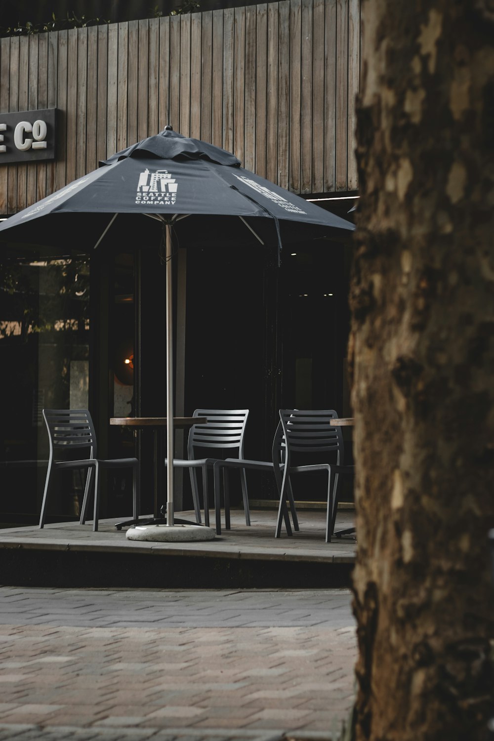 a restaurant with tables and chairs under a black umbrella