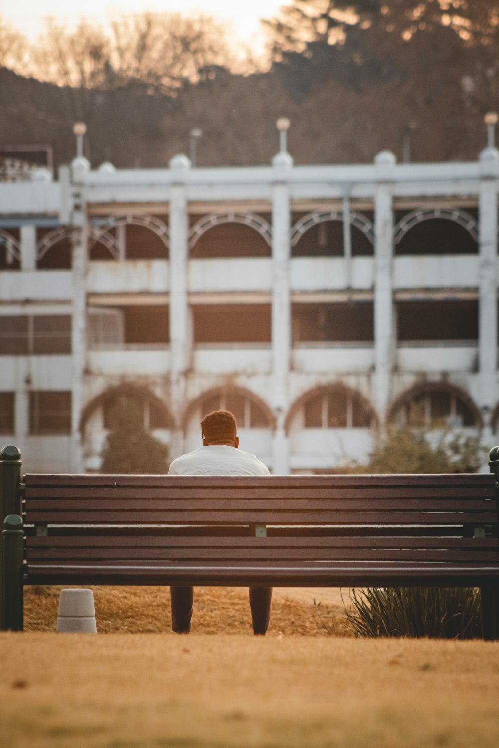 a man sitting on a bench in front of a building