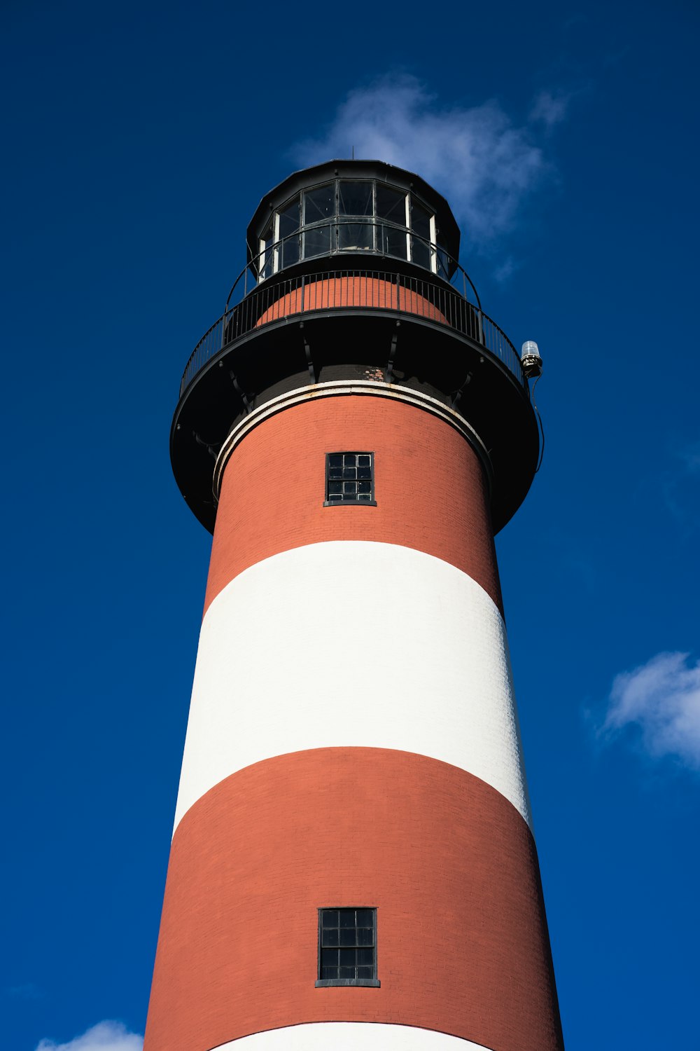 Ein rot-weißer Leuchtturm mit blauem Himmel im Hintergrund