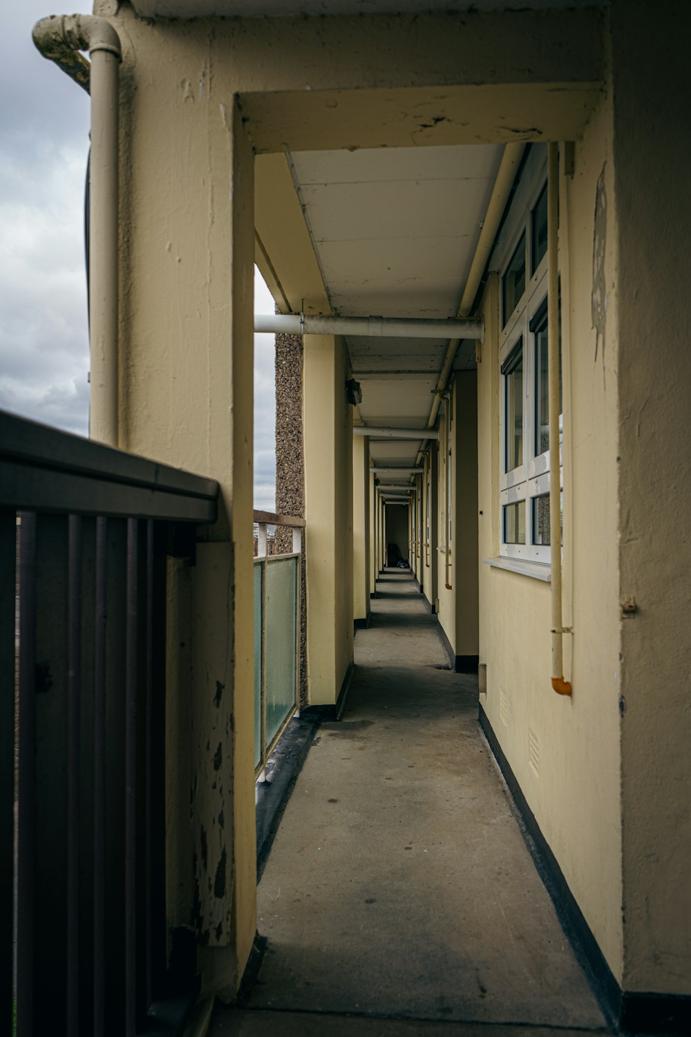 a long hallway leading to a building on a cloudy day