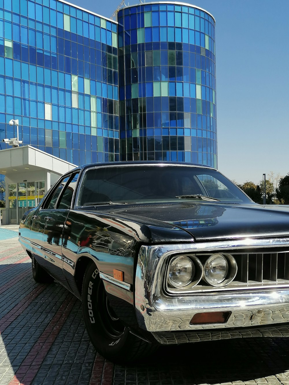 a black car parked in front of a tall building