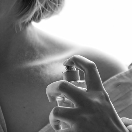 Artistic shot of hands applying scent on the wrist outdoors.