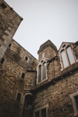 Architectural details of a medieval city-state’s fortified walls under a moody sky.