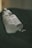 A close-up view of two frosted dropper bottles lying on a dark green fabric. The bottles are labeled with text, including 'The Ordinary,' and appear to be skincare products. The lighting is soft, casting gentle shadows and creating a slightly moody atmosphere.