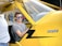 a man sitting in the cockpit of a yellow plane