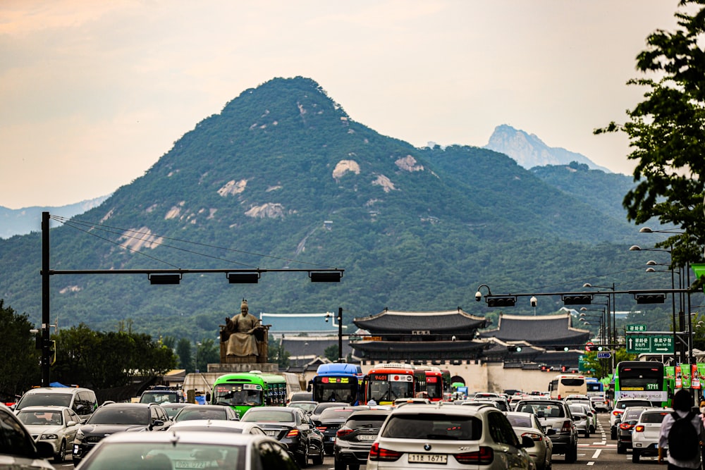 a busy city street with a mountain in the background