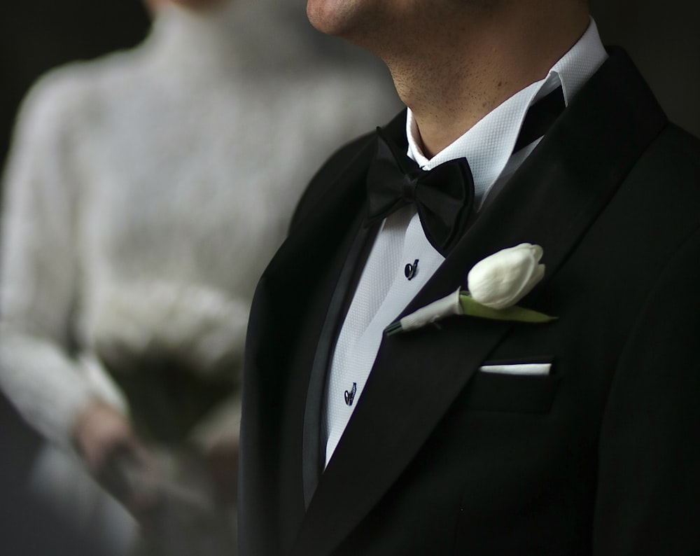 a man in a tuxedo with a flower in his lapel