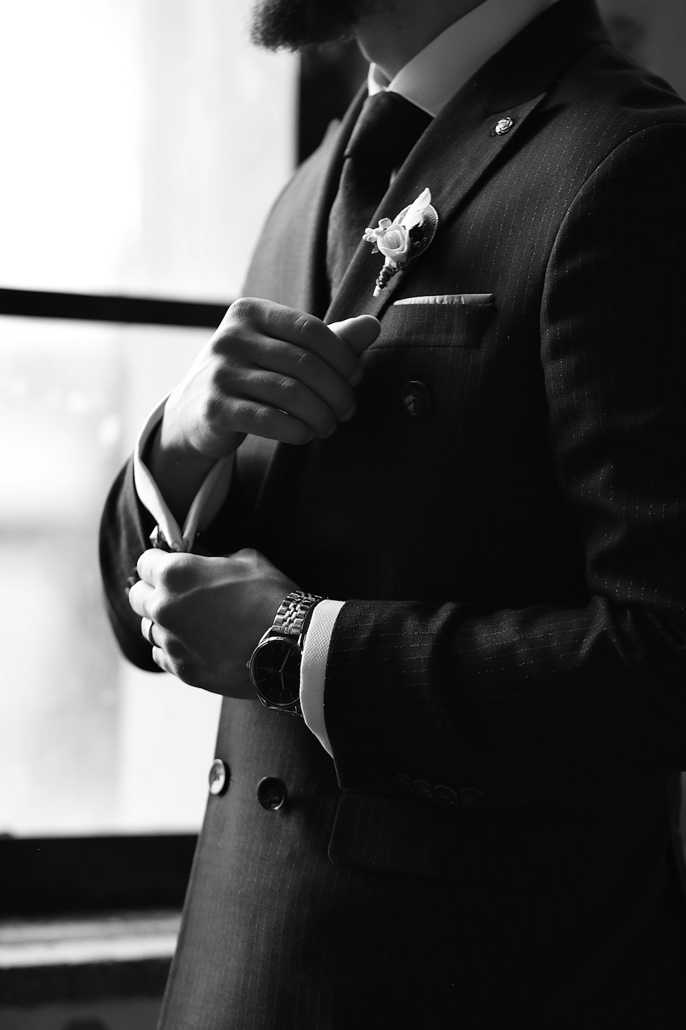 a man in a suit is adjusting his tie