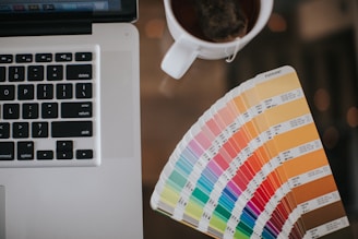a laptop computer sitting on top of a desk next to a cup of coffee