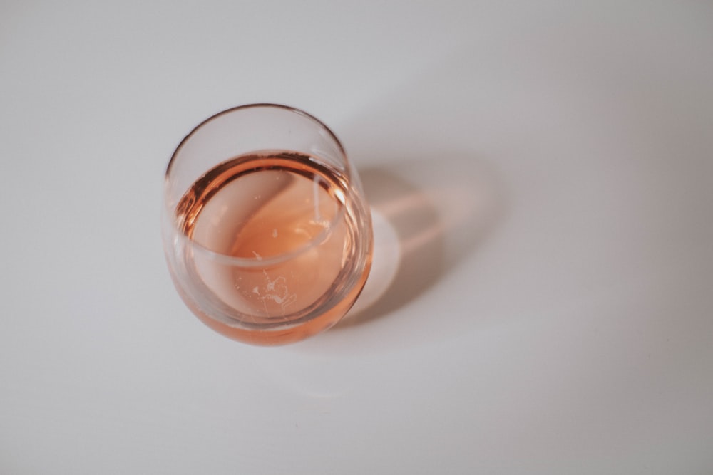 a glass of wine sitting on top of a white table