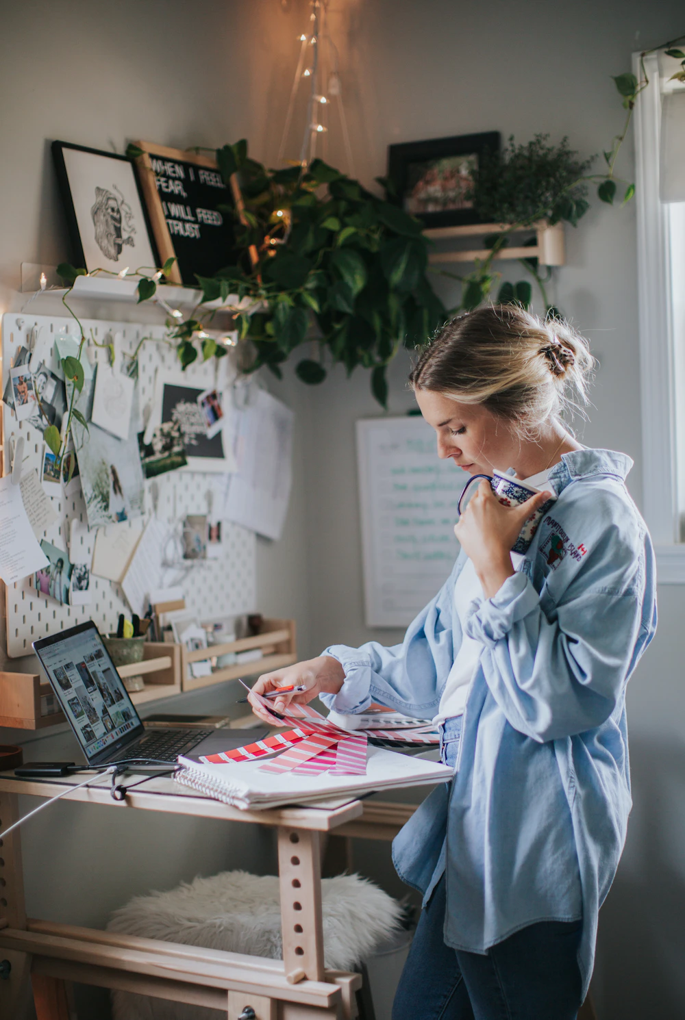Lena working at her desk with sketches on the wall