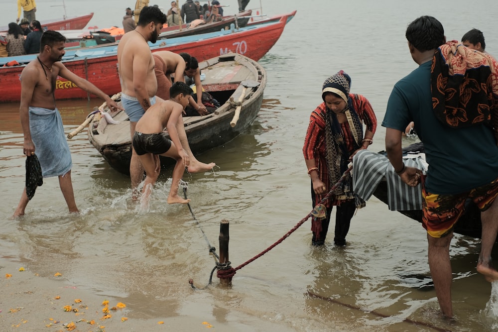 a group of people standing in the water next to boats