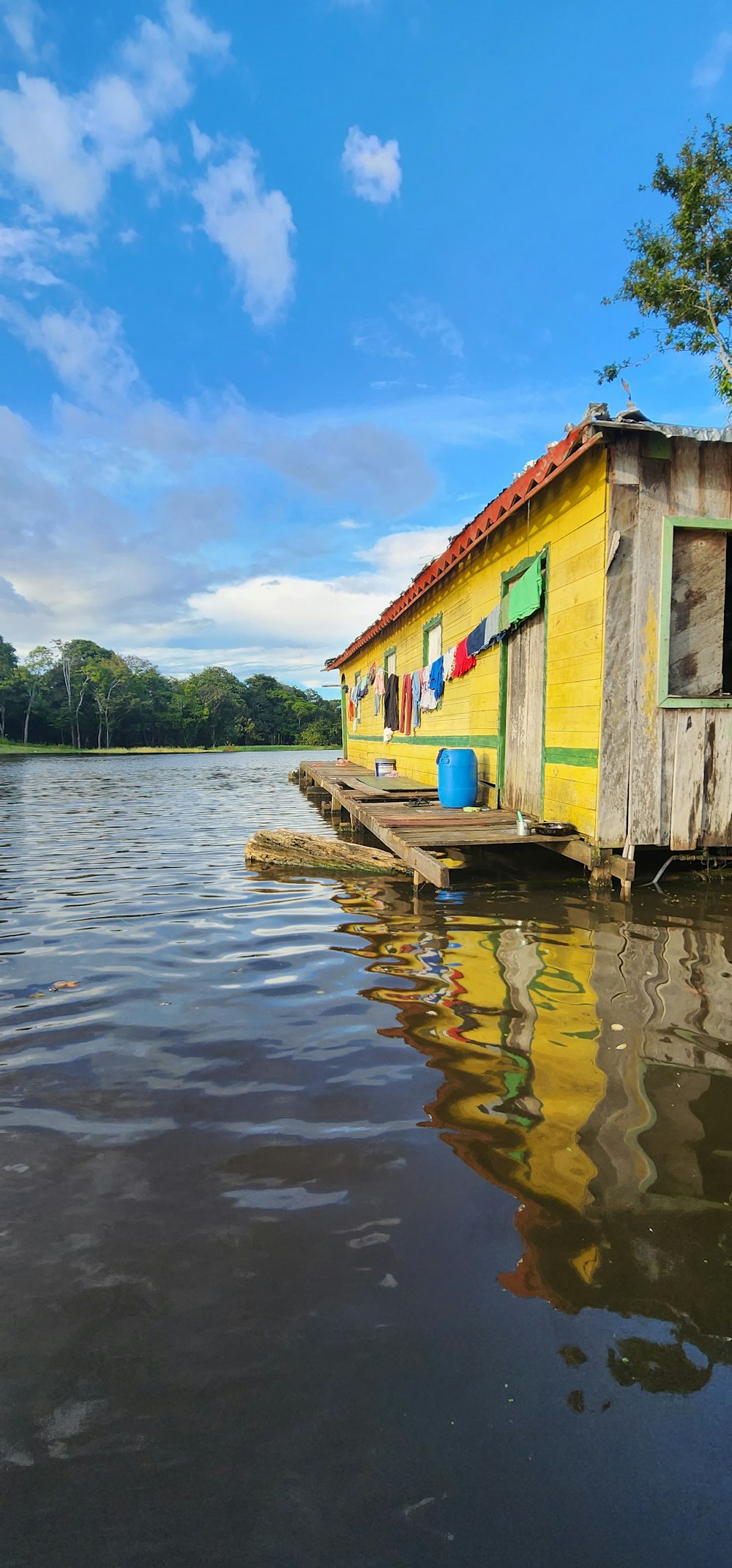 a yellow house sitting on top of a body of water