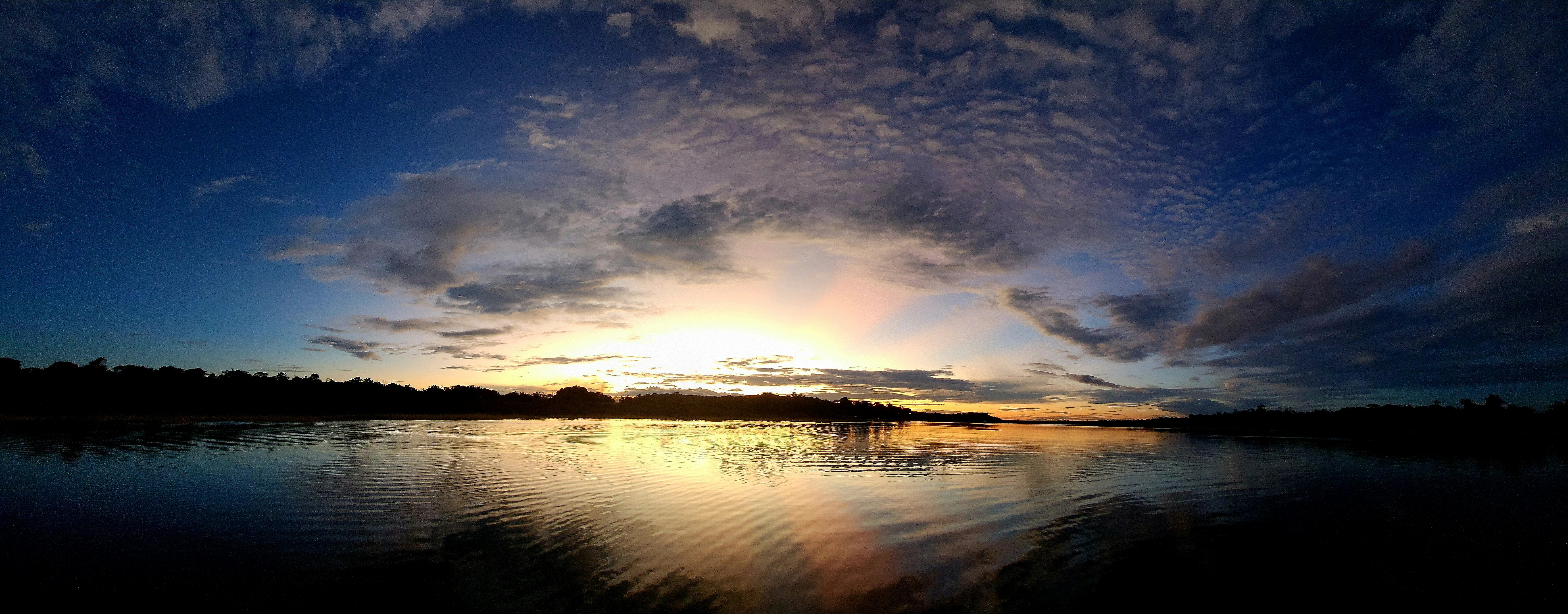 the sun is setting over a body of water, 