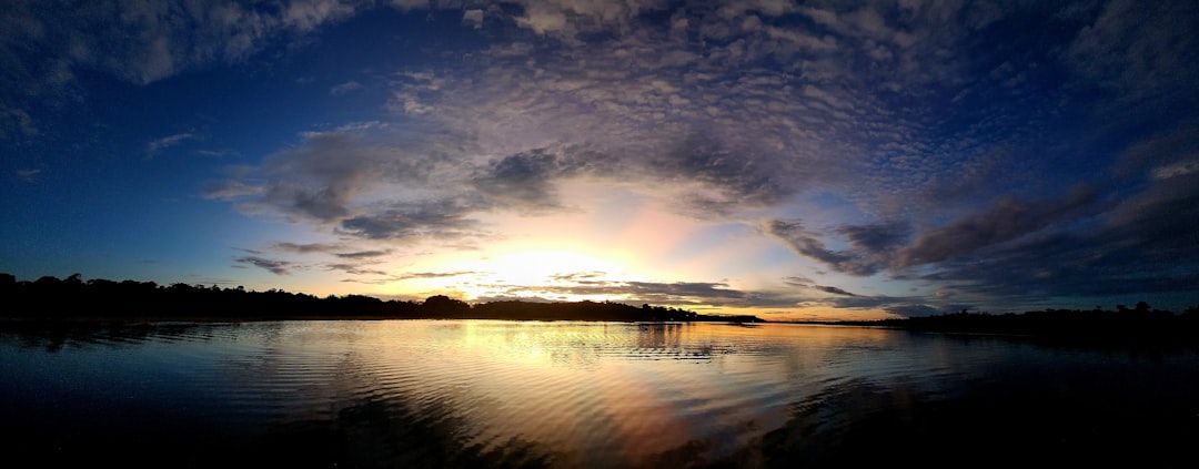 the sun is setting over a body of water,