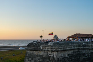 a group of people standing on top of a stone wall