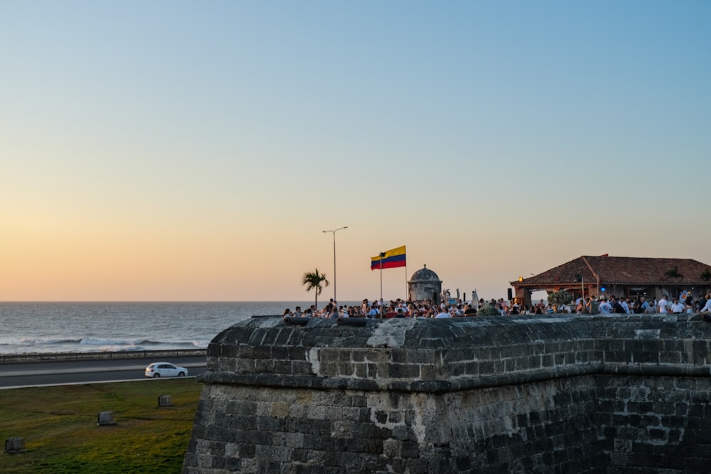 a group of people standing on top of a stone wall