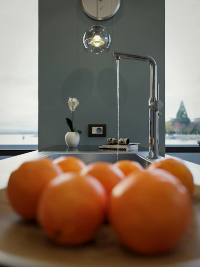 Bright kitchen setting featuring a premium American-made faucet with water flowing smoothly into a farmhouse sink.